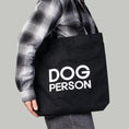 Bild in Galerie-Betrachter laden, Schwarzer Jutebeutel mit weißem „Dog Person“-Print von Karma Hund, frontal fotografiert.