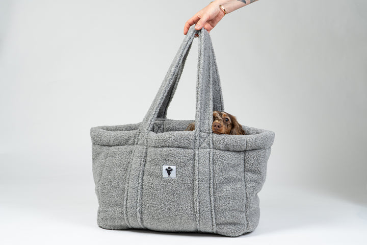 Zwergdackel liegt in der grauen Teddy Hundetasche von Karma Hund – kuscheliges mobiles Bett für unterwegs.