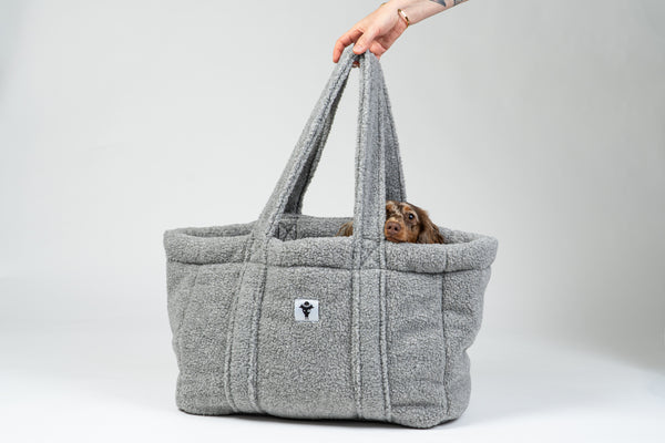 Zwergdackel liegt in der grauen Teddy Hundetasche von Karma Hund – kuscheliges mobiles Bett für unterwegs.